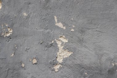 Soyulmuş gri duvar, terk edilmiş ve çökmüş bir duvarın ayrıntıları.