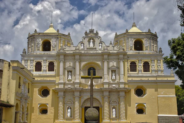 Antigua Guatemala 'daki paralı kilise. Önünde haç olan sarı barok kilisesi..
