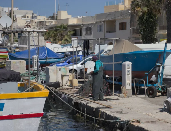 MARSAXLOKK, MALTA - Mayıs 2019: Maltalı balıkçı ağları günlük balıkçılık gezileri için hazırlıyor.