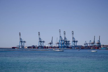 Tersanede çalışan vinç köprüsü olan konteyner kargo gemisi ve kargo uçağının lojistik ve taşımacılığı. Uzaktan bakıldığında.