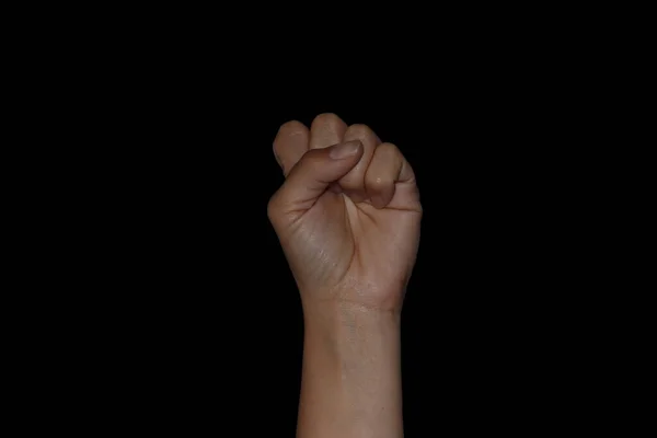 Puño de mujer sobre fondo negro. Mostrando conceptos de empoderamiento femenino, revolución y huelga . — Foto de Stock