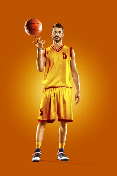 Bright professional basketball player on an orange background — Stock fotografie