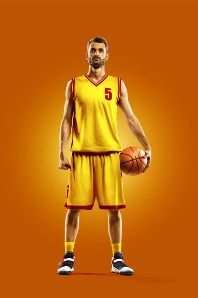 Bright professional basketball player on an orange background — Stock fotografie