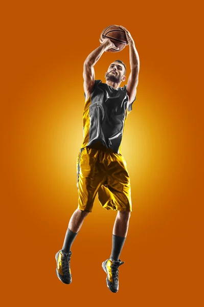 Bright professional basketball player on an orange background — Stockfoto