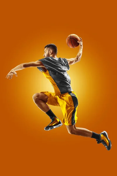 Profesjonell basketballspiller på oransje bakgrunn – stockfoto