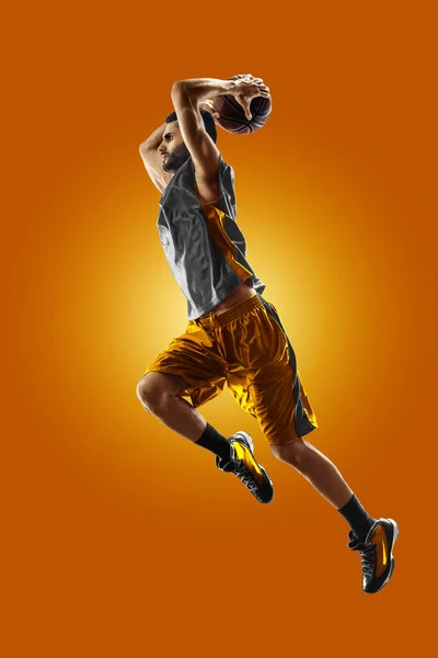 Bright professional basketball player on an orange background — Stok fotoğraf
