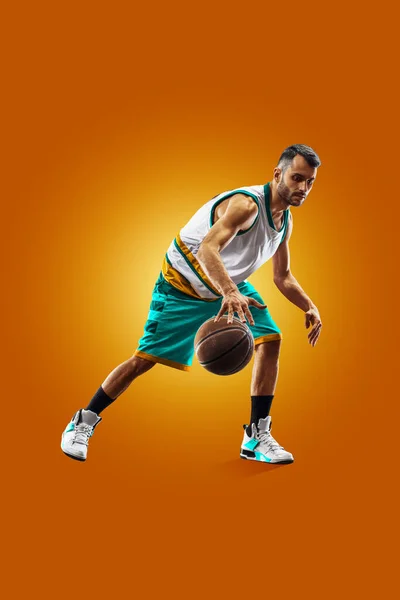 Bright professional basketball player on an orange background — Stock fotografie