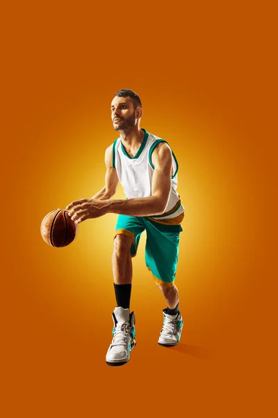 Bright professional basketball player on an orange background — Stock Photo, Image