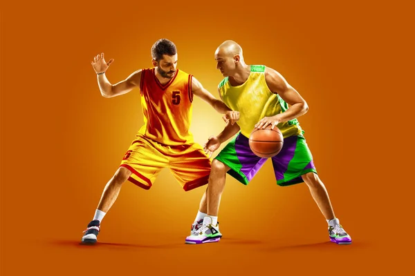 Jogadores de basquete profissionais coloridos isolados sobre fundo laranja — Fotografia de Stock