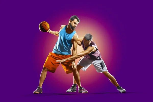 Coloridos jugadores profesionales de baloncesto aislados sobre fondo púrpura — Foto de Stock