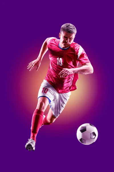 Kolorowy profesjonalny piłkarz odizolowany na fioletowym tle — Zdjęcie stockowe