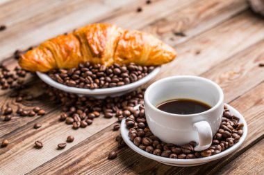 Kahvaltı kahve - Kupası, şeker, süt kabı ve kruvasan kahve çekirdekleri ile.