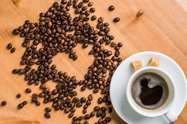 Coffee cup, sugar and coffee beans on wooden background. — Stock Photo, Image