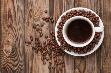 Ahşap arka planda kahve fincanı ve kahve çekirdeği..