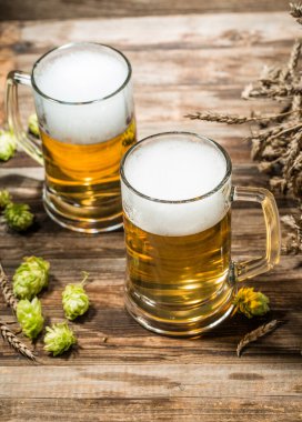 İki bardak bira ahşap masanın üstünde. Zıpzıp, üst manzara.