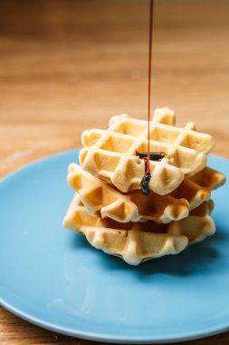 Ev yapımı waffle 'lar Mavi tabağa çikolata serpiştirir