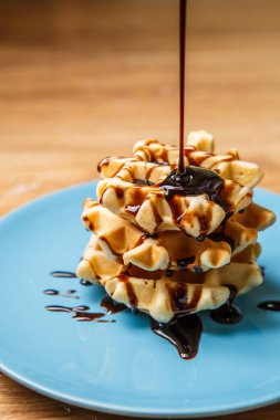 Ev yapımı waffle 'lar Mavi tabağa çikolata serpiştirir