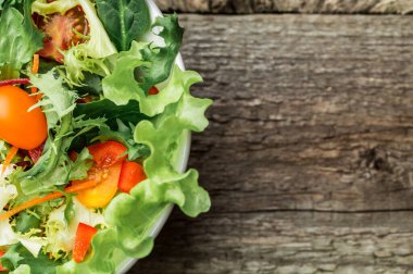 Taze sebze - domates, havuç, biber ve karışık yeşillik - roka salata, mesclun mache - ahşap arka plan üzerinde.