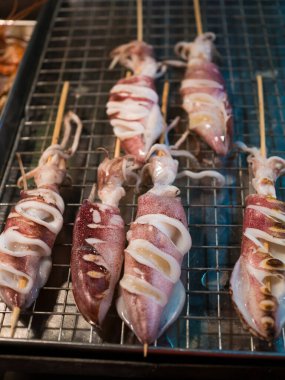Şişlerin üzerinde taze deniz ürünleri olan sokak dükkanının fotoğrafı.