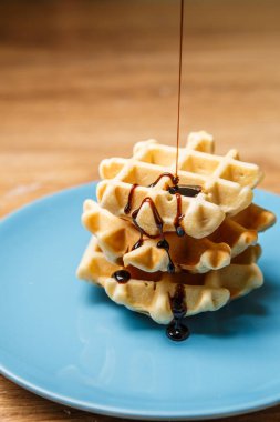 Ev yapımı waffle 'lar Mavi tabağa çikolata serpiştirir
