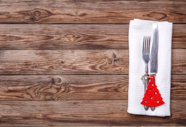 Çatal ve bıçakla döşenmiş Noel masası, süslü Noel oyuncağı - kırmızı köknar ağacı. Noel tatili geçmişi.