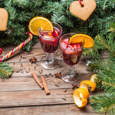 Portakallı, elmalı ve baharatlı iki bardak sıcak şarap. Noel arkaplanı.
