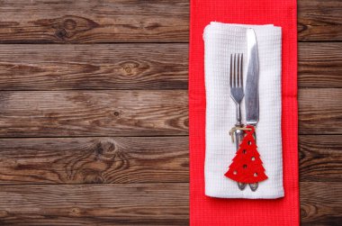 Çatal ve bıçakla döşenmiş Noel masası, süslü Noel oyuncağı - kırmızı köknar ağacı. Noel tatili geçmişi.