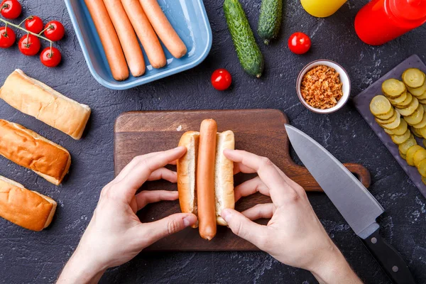 Obraz Góry Człowieka Robi Hot Dogi Stole Deską Krojenia — Zdjęcie stockowe