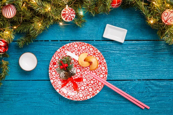 Photo Christmas Branches Pine Sushi Sticks Prediction Cookies Plates Red — 图库照片