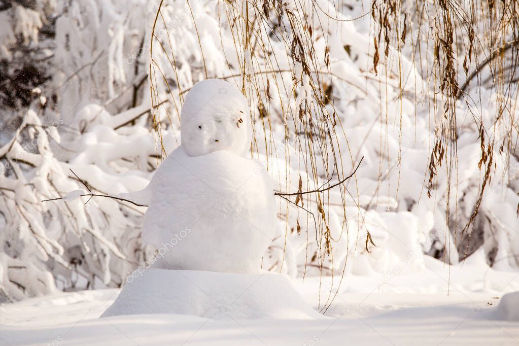 Undecorated snowman in winter landscape in sunny day
