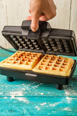 Waffle ızgarasında waffle. Evde waffle yapıyorum. Aşçılık arkaplanı.