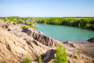 Resimli bir tepe fotoğrafı. Yaz günü bitki örtüsü ve mavi göl.
