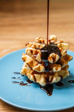 Ev yapımı waffle 'lar Mavi tabağa çikolata serpiştirir