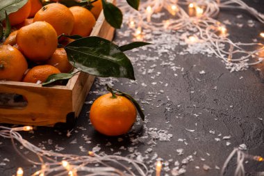 Ahşap kutuda mandalina resmi. Üzerinde yanan bir çelenk var.