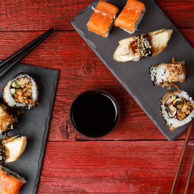 Kırmızı ahşap masada, kara tahtalarda servis edilir.