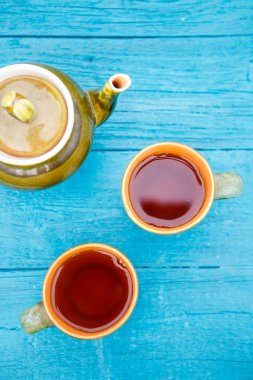 Çaydanlık ve çay mavi masada.