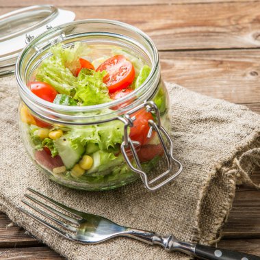Tahta masada temiz bez ve çatalla taze salata.