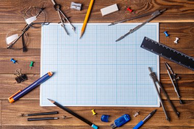 Kopyalama alanı ve ahşap masa üzerinde öğrenci materyali olan grafikler. Üst görünüm