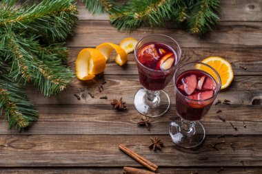 Portakallı, elmalı ve baharatlı iki bardak sıcak şarap. Noel arkaplanı.