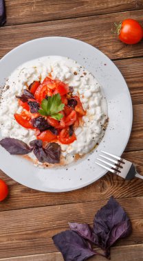 Süzme peynirli salata ve ahşap masada domates. Top wiev. Taze yemek..