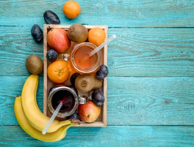 Mavi arka planda meyveli meyve suyu bardakları