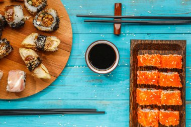 Yuvarlak ahşap tahta ve mavi masadaki tabaklar