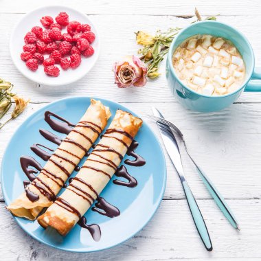 Ev yapımı krep ya da beyaz ahşap arka planda çikolata soslu Rus blini. Üst görünüm