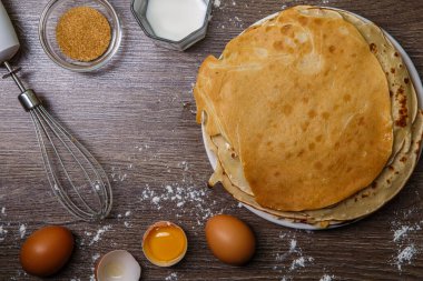 Kahverengi ahşap masada krep, un, yumurta ve çırpı