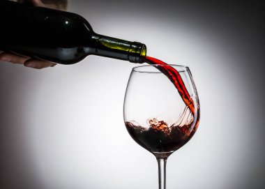 Şarap şişeden şarap kadehine boş bir arkaplandan dökülüyordu.