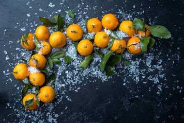 Siyah masada karlı mandalina fotoğrafı.