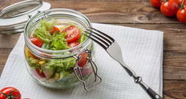 Sebzeler kavanozda, çatal ve bez temizleme masasında.