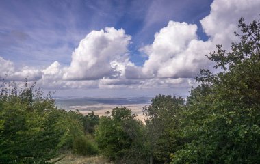 Gökyüzü ve bulutların arkasındaki dağlardan, vadiden ve ormandan manzara manzarası