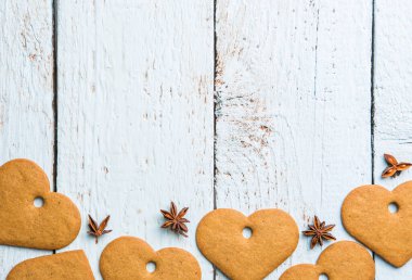 Beyaz ahşap arka planda Noel dekoru ve kalp şeklinde kurabiyeler. Noel geçmişleri. Yukarıdan görüntüle