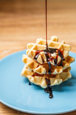 Ev yapımı waffle 'lar Mavi tabağa çikolata serpiştirir